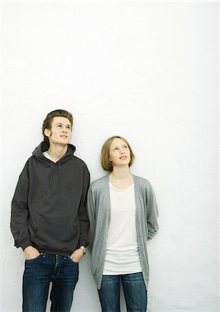 Young couple leaning against wall, looking up Stock Photo - Premium Royalty-Free, Code: 695-05765100