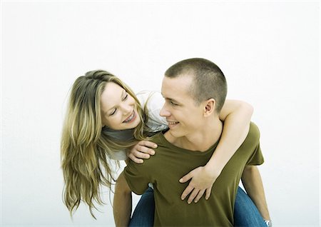 Young couple, teenage girl on young man's back, white background Stock Photo - Premium Royalty-Free, Code: 695-05765121