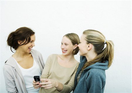 Young female friends looking at cell phone together Stock Photo - Premium Royalty-Free, Code: 695-05765134