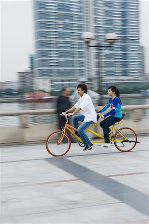 simsearch:695-03378158,k - Couple riding tandem bicycle Fotografie stock - Premium Royalty-Free, Codice: 695-05765154