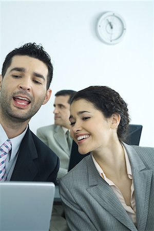simsearch:632-01155400,k - Business associates working on computer, man talking and woman smiling Stock Photo - Premium Royalty-Free, Code: 695-05765178