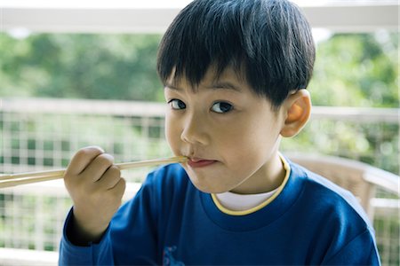 Boy eating with chopsticks Stock Photo - Premium Royalty-Free, Code: 695-05765249