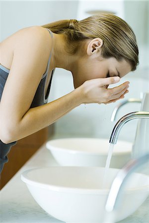 Woman washing face over sink, side view Stock Photo - Premium Royalty-Free, Code: 695-05765390