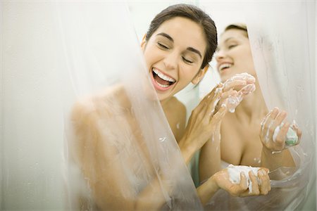 Woman handing friend soap in public showers Fotografie stock - Premium Royalty-Free, Codice: 695-05765400