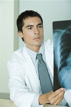 doctor looking at xray - Doctor studying x-ray Stock Photo - Premium Royalty-Free, Code: 695-05765414