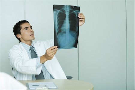 doctor looking at xray - Doctor holding up x-ray Stock Photo - Premium Royalty-Free, Code: 695-05765415
