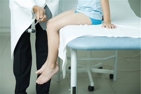 doctor with patient kids bed - Doctor checking boy's reflexes with reflex hammer Foto de stock - Sin royalties Premium, Código: 695-05765429