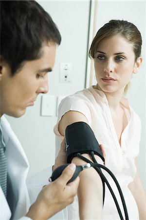 Doctor taking woman's blood pressure Stock Photo - Premium Royalty-Free, Code: 695-05765435