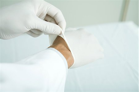 Doctor putting on latex gloves, close-up Foto de stock - Sin royalties Premium, Código: 695-05765444