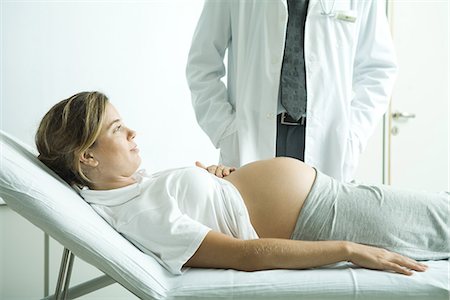 Pregnant woman lying on back, doctor standing next to her Stock Photo - Premium Royalty-Free, Code: 695-05765467