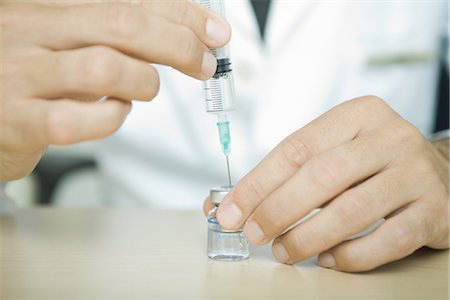 Doctor filling syringe from bottle Stock Photo - Premium Royalty-Free, Code: 695-05765474