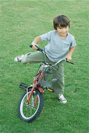 riding bike with basket - Boy getting on bike, on grass, high angle view, full length Stock Photo - Premium Royalty-Free, Code: 695-05765555
