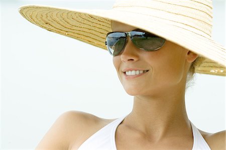 Young woman wearing sunhat and sunglasses, smiling Stock Photo - Premium Royalty-Free, Code: 695-05765569