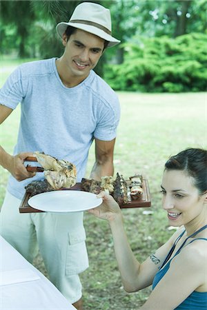 food tattoos - Man serving woman grilled meat during cookout Stock Photo - Premium Royalty-Free, Code: 695-05765586