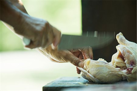 raw chicken on cutting board - Man cutting up chicken, blurred motion, close-up Stock Photo - Premium Royalty-Free, Code: 695-05765608