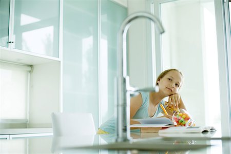 Girl eating sweets and doing homework Stock Photo - Premium Royalty-Free, Code: 695-05765611
