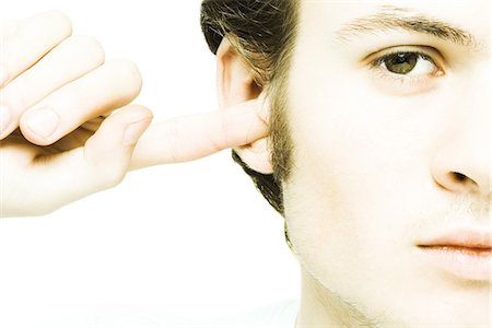 plugging ears - Jeune homme, brancher l'oreille avec le doigt Photographie de stock - Premium Libres de Droits, Code: 695-05765719