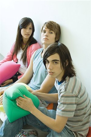 floor cushion - Three teen friends sitting on floor, holding cushions Stock Photo - Premium Royalty-Free, Code: 695-05765754