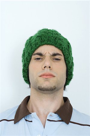 Young man wearing knit hat, furrowing brow, portrait, close-up Stock Photo - Premium Royalty-Free, Code: 695-05765862