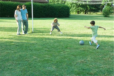 Boys playing soccer while parents watch Stock Photo - Premium Royalty-Free, Code: 695-05765948