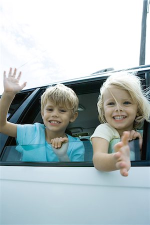 simsearch:695-05767597,k - Children sticking heads out of car window, waving Fotografie stock - Premium Royalty-Free, Codice: 695-05766047