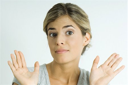 refuse - Young woman raising eyebrows, holding up palms, portrait Foto de stock - Sin royalties Premium, Código: 695-05766172