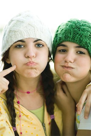 simsearch:695-05766502,k - Jeunes amis de femmes portant des chapeaux, de tricot soufflant sur les joues Photographie de stock - Premium Libres de Droits, Code: 695-05766250