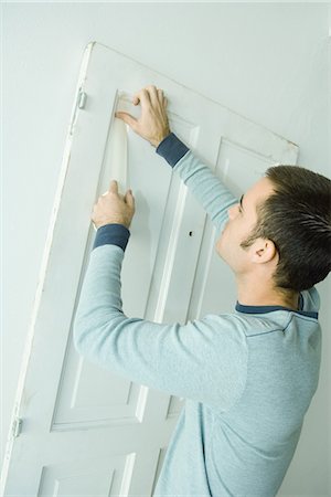 Man putting tape on door woodwork in preparation for painting Foto de stock - Sin royalties Premium, Código: 695-05766291