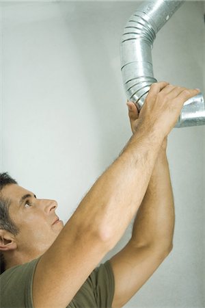 Man adjusting air duct Stock Photo - Premium Royalty-Free, Code: 695-05766310