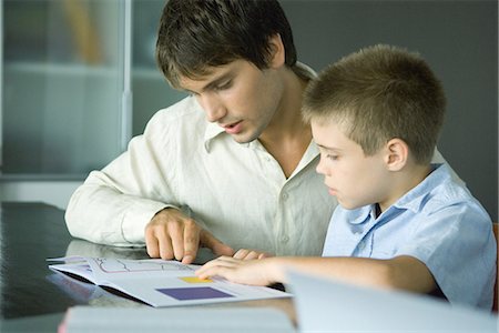 Man helping boy with homework Foto de stock - Sin royalties Premium, Código: 695-05766354