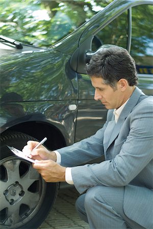 Mature man in suit inspecting car Foto de stock - Sin royalties Premium, Código: 695-05766451