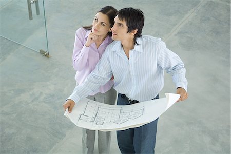 simsearch:696-03394263,k - Young couple holding blueprints, looking up, high angle view Foto de stock - Sin royalties Premium, Código: 695-05766465