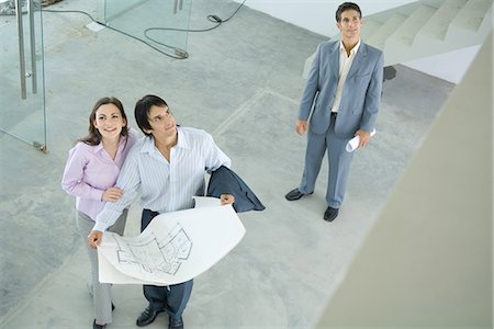 real estate agents and couples - Architect showing unfinished house to enthusiastic young couple, high angle view Stock Photo - Premium Royalty-Free, Code: 695-05766462