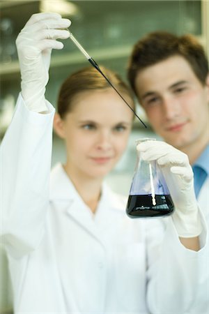 scientists standing together - Young male and female scientists, woman holding up dropper and flask Stock Photo - Premium Royalty-Free, Code: 695-05766479