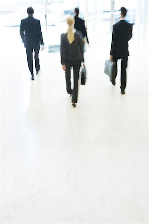 Business associates exiting lobby, rear view, blurred motion Stock Photo - Premium Royalty-Free, Code: 695-05766516