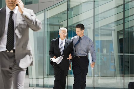 simsearch:695-05769904,k - Two businessmen walking together, discussing, building in background Foto de stock - Sin royalties Premium, Código: 695-05766526