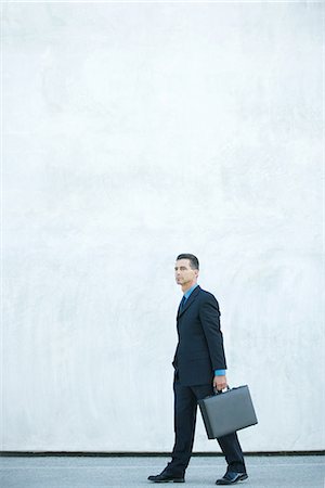 Homme d'affaires à pied, transportant des porte-documents, pleine longueur Photographie de stock - Premium Libres de Droits, Code: 695-05766583