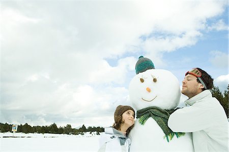 Brother and sister leaning against snowman, both smiling, brother's eyes closed Stock Photo - Premium Royalty-Free, Code: 695-05766596