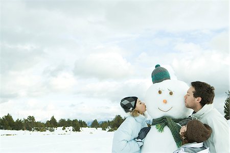 puckered lips profile - Three young friends kissing snowman, head and shoulders Stock Photo - Premium Royalty-Free, Code: 695-05766599