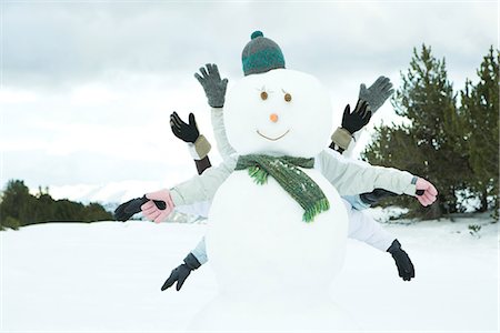 snow cone - Jeunes amis se cachant derrière un bonhomme de neige, bras tendus Photographie de stock - Premium Libres de Droits, Code: 695-05766601
