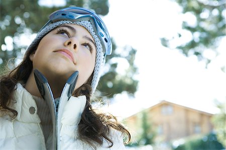 skiing chalet - Teenage girl with skis, looking up Stock Photo - Premium Royalty-Free, Code: 695-05766618