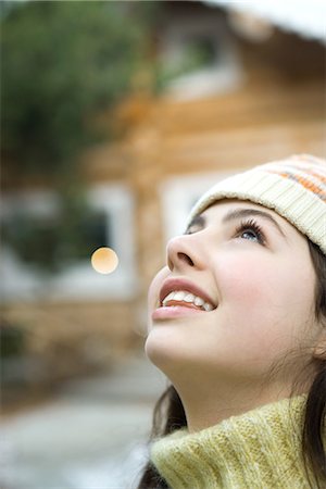 Teenage girl looking up, close-up, chalet in background Stock Photo - Premium Royalty-Free, Code: 695-05766613