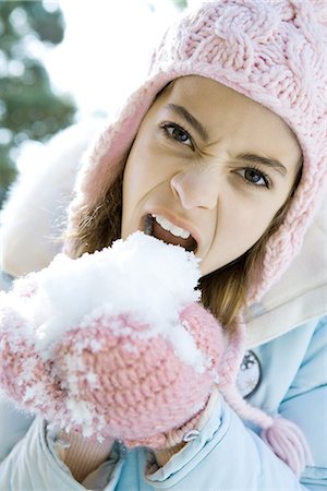 simsearch:695-03375570,k - Préados fille manger la neige hors main gantée, grondants et regarder la caméra Photographie de stock - Premium Libres de Droits, Code: 695-05766622