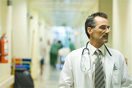 simsearch:400-07334526,k - Male doctor looking away, hospital corridor in background Stock Photo - Premium Royalty-Free, Code: 695-05766644
