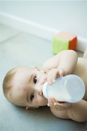 simsearch:695-05778625,k - Baby lying on floor, drinking from bottle Stock Photo - Premium Royalty-Free, Code: 695-05766781