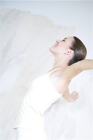 Woman leaning back, arms outstretched, smiling, side view Stock Photo - Premium Royalty-Free, Code: 695-05766935