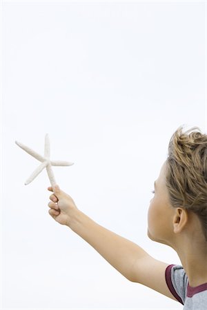 simsearch:632-01156899,k - Boy holding up starfish, cropped side view Fotografie stock - Premium Royalty-Free, Codice: 695-05767219