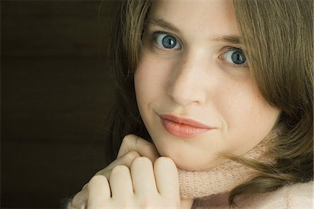 portrait close up dark background - Teen girl holding sweater neck, looking at camera, portrait Stock Photo - Premium Royalty-Free, Code: 695-05767276
