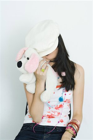 simsearch:600-06773114,k - Teenage girl hiding face with stuffed toy, laughing Stock Photo - Premium Royalty-Free, Code: 695-05767285