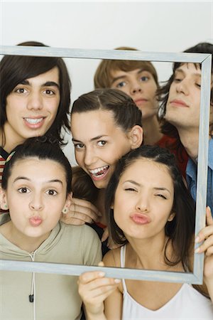 Jeunes amis en regardant la caméra par le biais de cadre photo, portrait de groupe Photographie de stock - Premium Libres de Droits, Code: 695-05767318